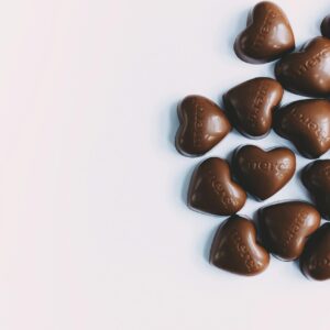 Flat lay of heart-shaped milk chocolates with 'merci' text, perfect for gifting.